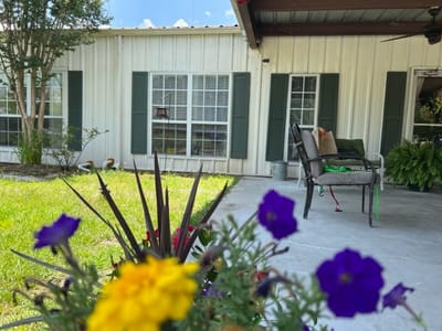 Outdoor seating area with flowers in front of a facility
