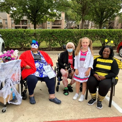 Residents and staff celebrating in costumes outdoors