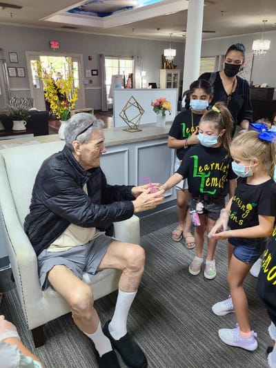 A resident interacting with young children in a common area