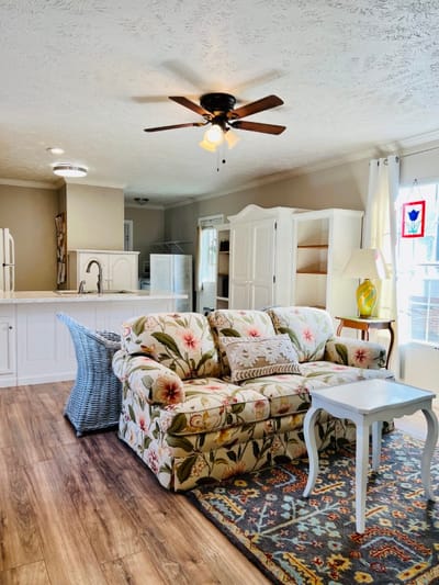 Bright, inviting common area with floral couch and decor