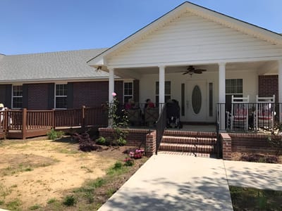 Exterior view of Lynnwood Senior Care with residents on the porch
