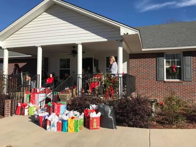 Residents and staff outside a decorated building during the holidays