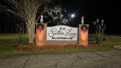 Facility entrance sign at night with holiday decorations