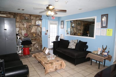 Living room area with couch and stone wall.