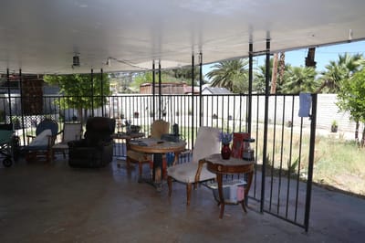 Outdoor seating area with chairs and plants.