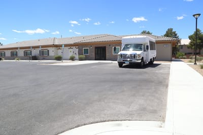 Facility exterior with a transport van parked.