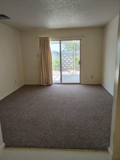 Empty resident room with sliding door and carpet