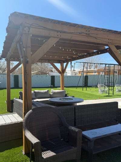Outdoor seating area with a pergola and green grass