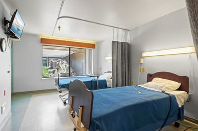 Private resident room with two beds and a window view