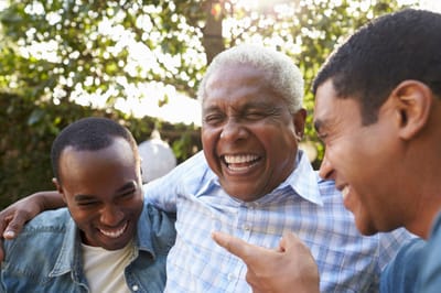 Three men laughing together outdoors