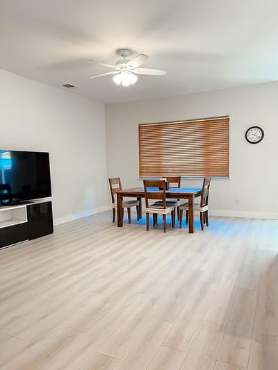 Bright interior space with a dining table and TV.