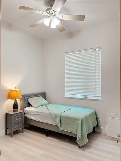 Brightly lit private resident room with a bed