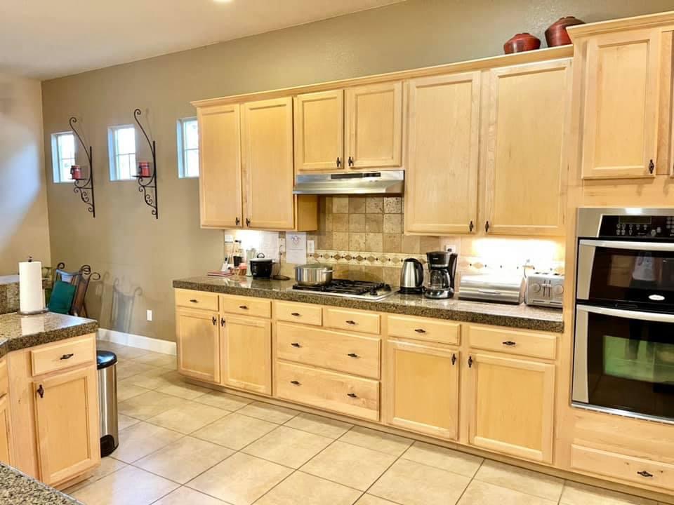Bright kitchen area with wooden cabinets and appliances