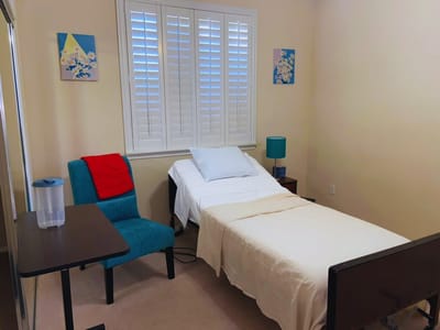 A private resident room with a bed and chair