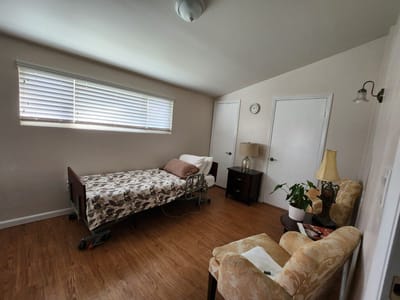 A private resident room with a bed and seating area