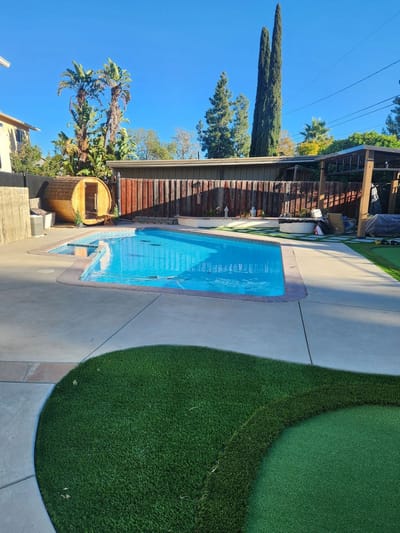 Outdoor pool area surrounded by palms and patio space