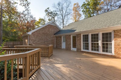Outdoor deck area with wooden railings and landscaping