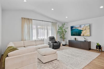 Bright, spacious common area with seating and a large TV.
