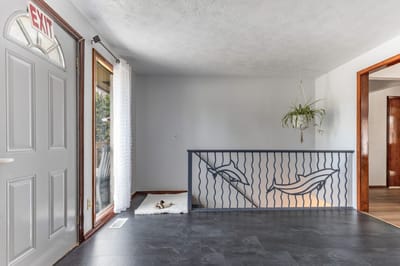 Bright interior space with an exit door and decorative railing