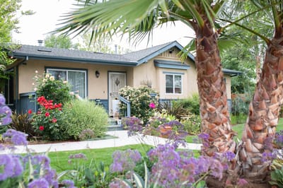 Exterior view of a cottage surrounded by flowers
