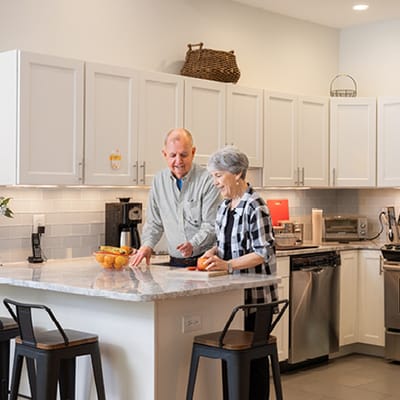 Two residents engaging in cooking at a kitchen island
