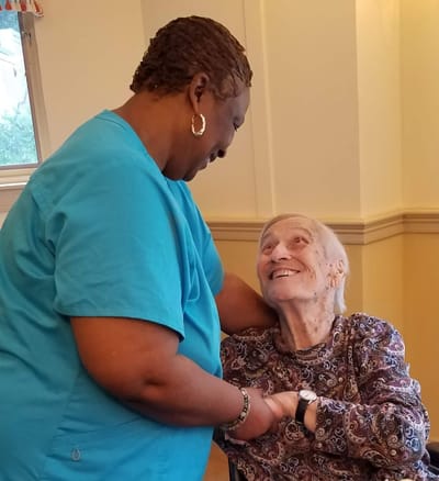 Staff member interacting with a smiling resident