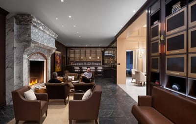 Residents relaxing in a cozy common area with a fireplace