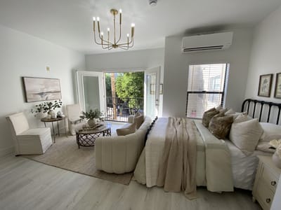 Bright, comfortable resident room with furniture and balcony access