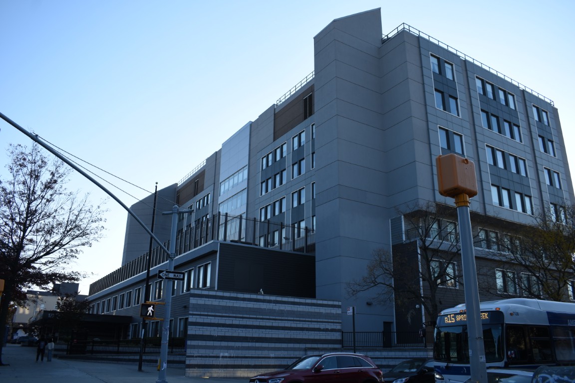 Exterior view of the nursing facility with a parked bus.