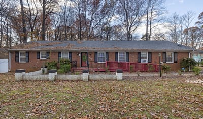 Exterior view of Rose Care Home surrounded by fallen leaves.