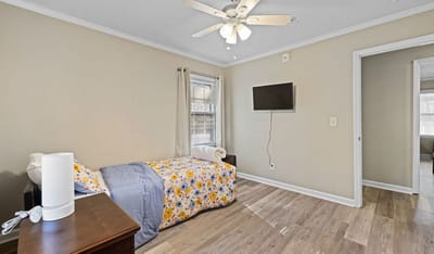 Brightly decorated resident room with a bed and TV.