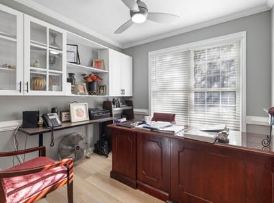 Brightly lit office with a desk and shelves
