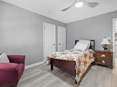 Cozy resident room with floral bedding and lighting.