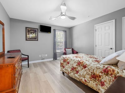 Cozy resident room with floral bedding and furniture.