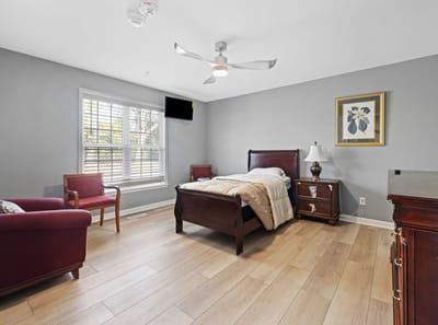 Well-furnished private resident room with a bed and seating area.