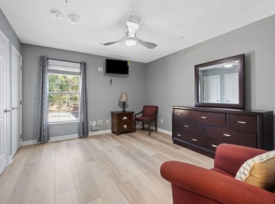 Cozy private room with a dresser and window.
