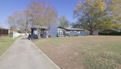 Exterior view of Rose Care Home with pathway and lawn.