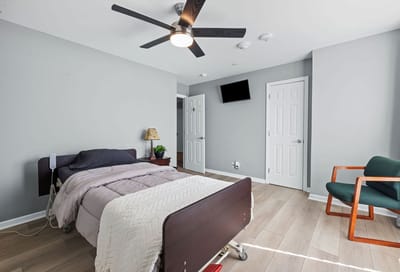 Cozy resident room with bed and seating area.