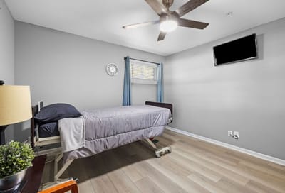 Private resident room with bed and TV.
