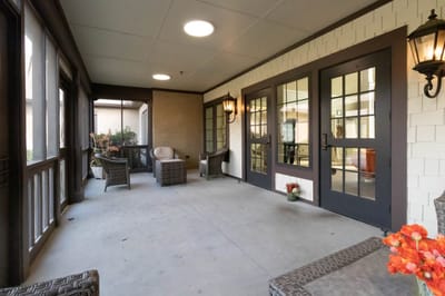 Covered porch area with seating and lanterns