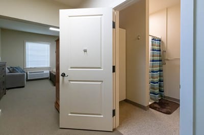 Private resident room with an open door and bathroom nearby
