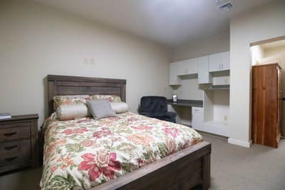 Cozy resident room with floral bedding and seating area