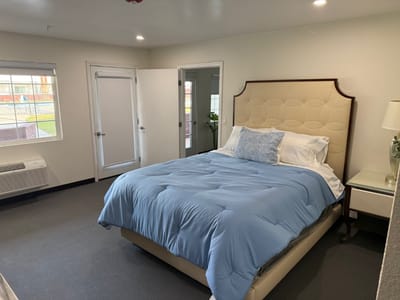 Comfortable bedroom with a blue blanket and a chair