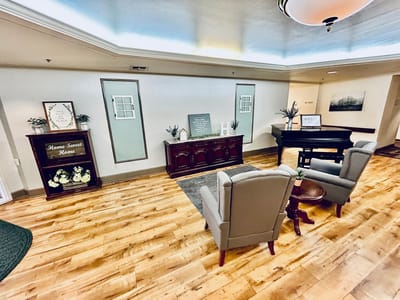 Common area with seating and piano in a cozy setting