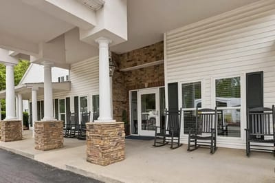 Exterior view of the facility entrance with rocking chairs
