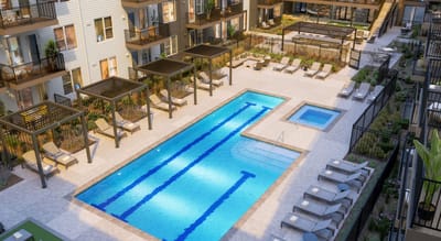 Aerial view of a pool area with seating and cabanas