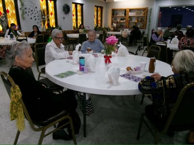 Seniors playing games at a dining room table