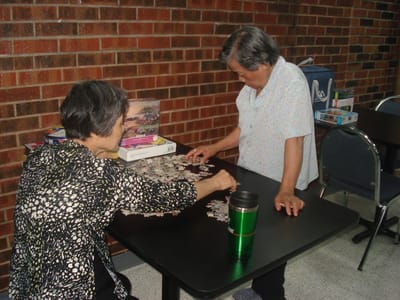Two residents working on a puzzle at a table