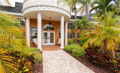 Welcoming entrance with tropical landscaping.
