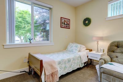 Cozy bedroom with a bed and comfortable chair.